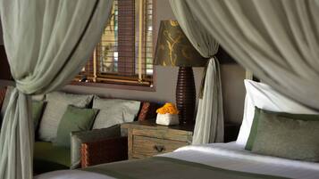 A bedroom with a bed, a nightstand, a lamp, and curtains.