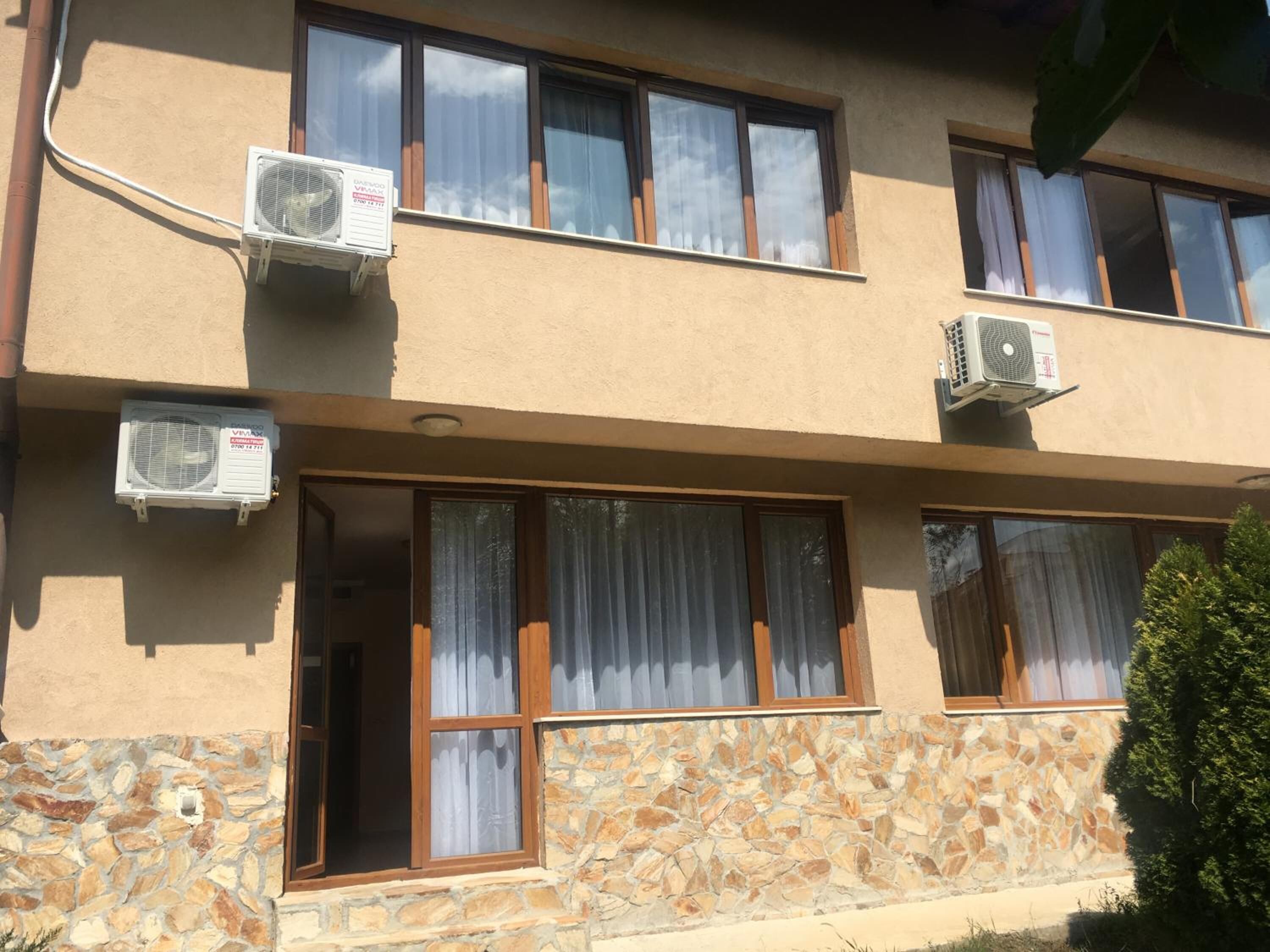 A two-story building with multiple air conditioning units mounted on the exterior walls.