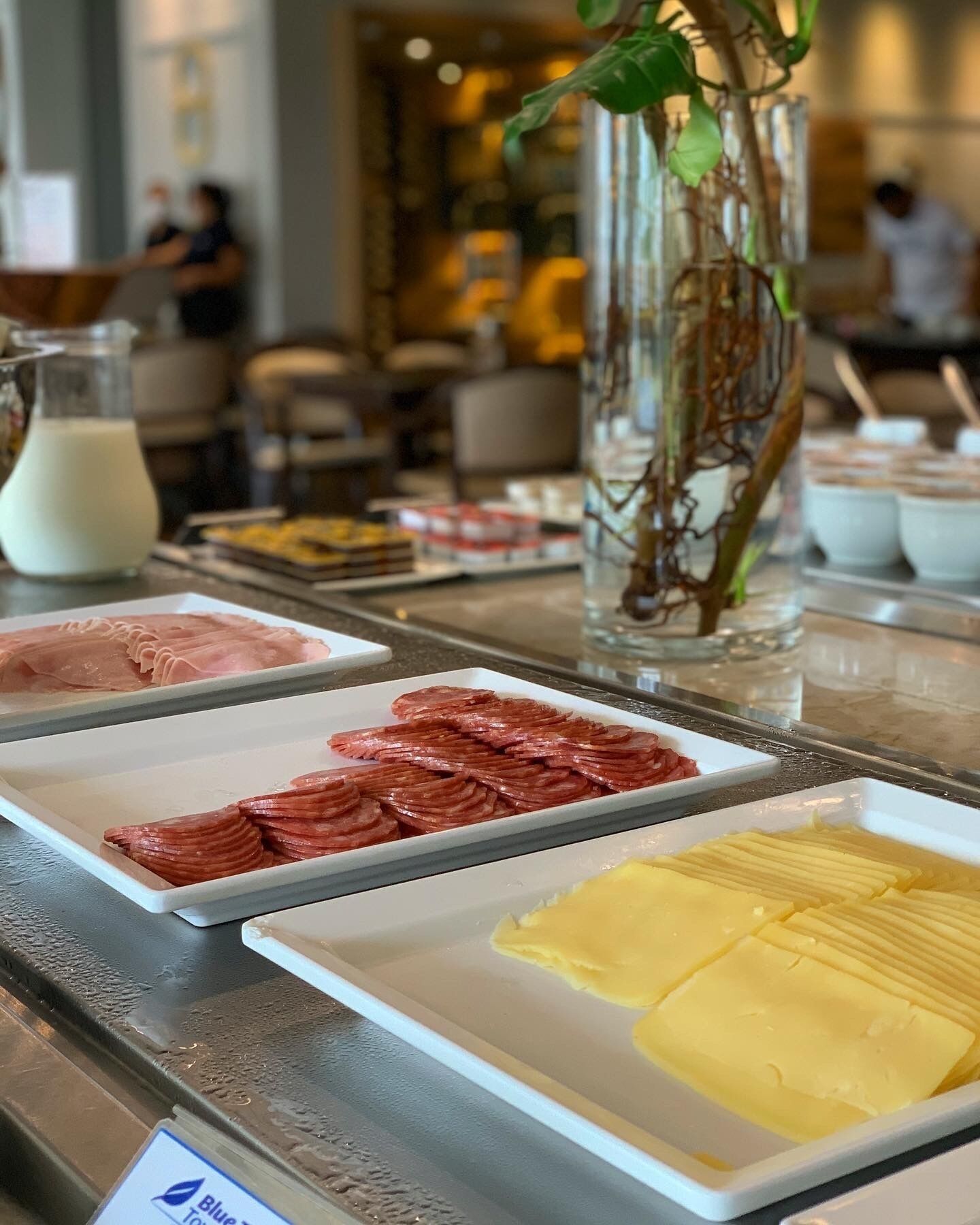 A buffet with various food items including sliced meats and cheese.