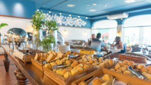 Un bufé con diversas opciones de panadería y un pastel sobre una mesa de madera.