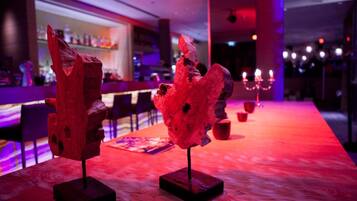 Eine Bar mit Holztischen und roter Beleuchtung.