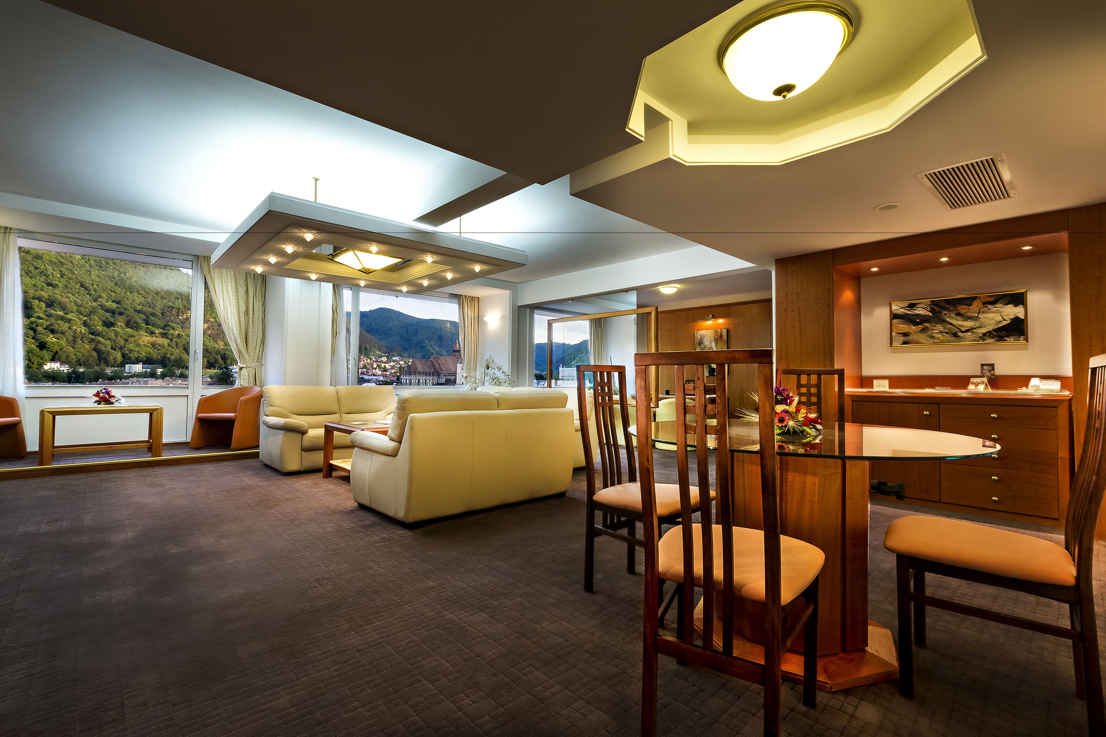 Una habitación de hotel moderna con sala de estar, comedor y cocina.
