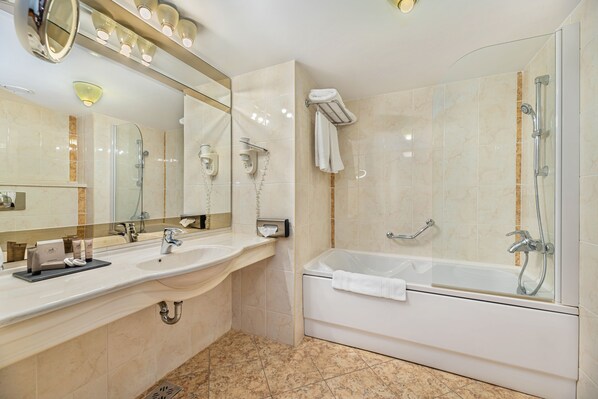 Un baño moderno con dos lavamanos, ducha con mampara de vidrio y bañera.