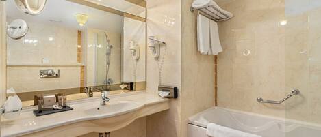 Un baño moderno con un espejo grande, un lavabo, una bañera y un perchero para toallas.