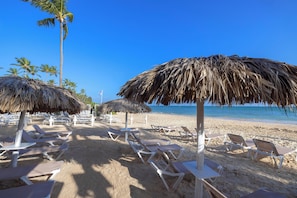 A beach with thatched umbrellas and lounge chairs. - whala!bavaro (Punta Cana)