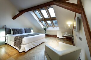 Een slaapkamer met een bed, een stoel, een bureau en een televisie.
