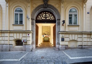 An entrance with an ornate archway, a cobblestone pathway, and a sign indicating a no-smoking area. - Eurostars Thalia (Prague)