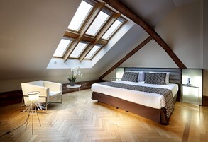 Una camera da letto moderna con un lucernario, un letto, un comodino e una sedia.