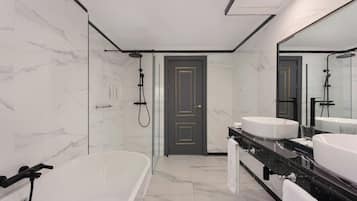 Un baño moderno con una bañera grande, dos lavamanos y una ducha a pie.