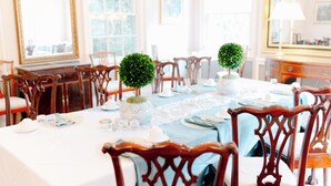 A dining room with a long table set for a meal, surrounded by wooden chairs. - Morehead Inn (Charlotte)