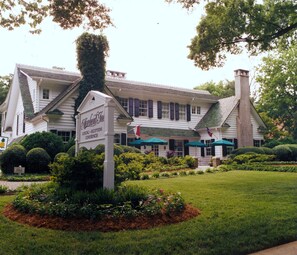 A white building with a sign reading "Morehead Inn" and a flag. - Morehead Inn (Charlotte)