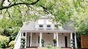 A white colonial-style house with a front porch, a central door, and a staircase leading to the upper floor. - Morehead Inn (Charlotte)