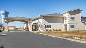 A multi-story hotel with a central entrance, a water tower, and a parking area. - Comfort Inn Bolivar (Bolivar)