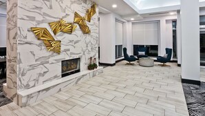 A modern living room with a marble wall, a fireplace, and contemporary furniture.