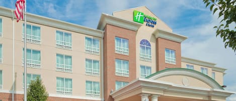 A Holiday Inn Express hotel with a brick facade, multiple windows, and a prominent American flag.