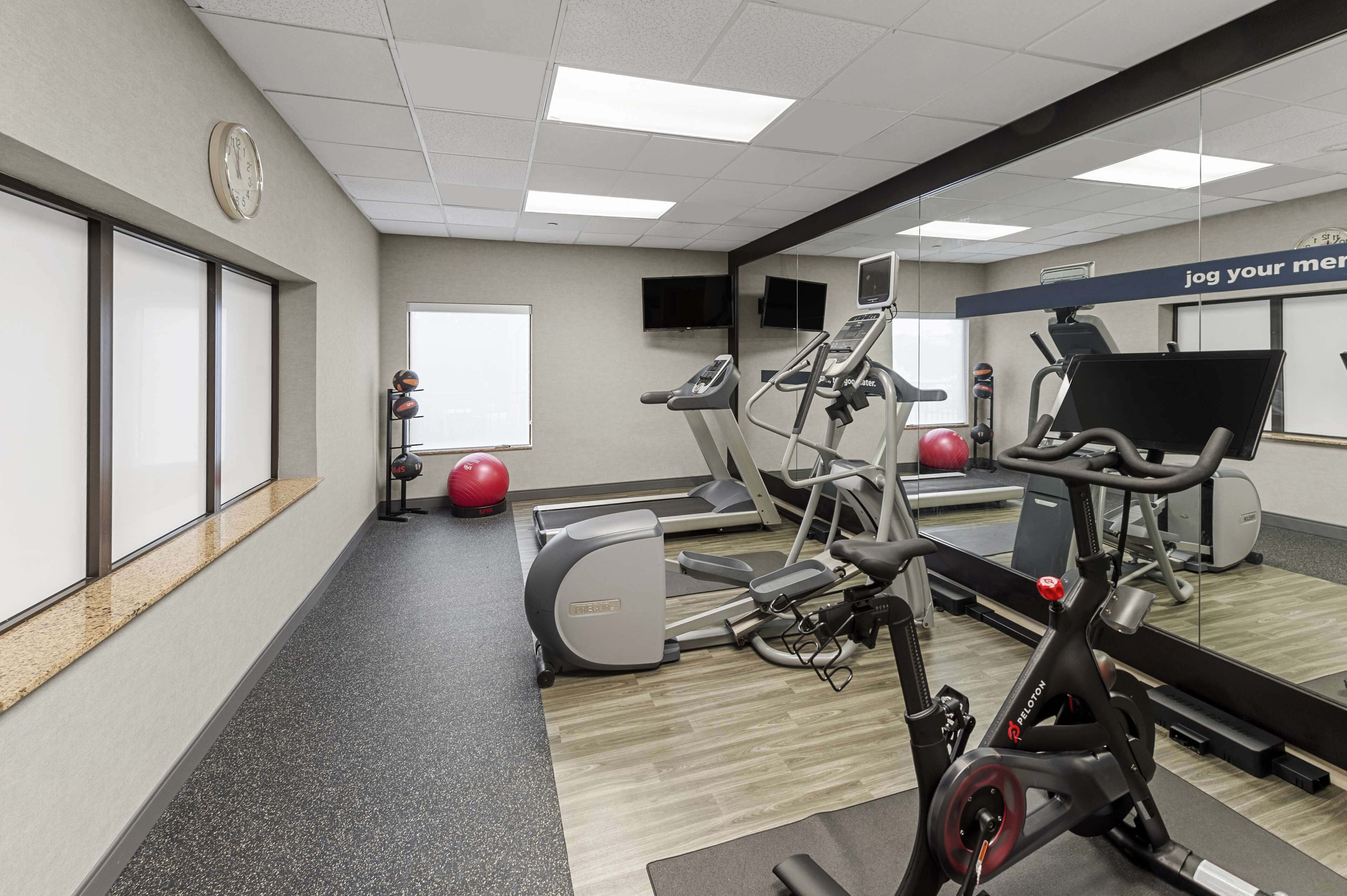 Ein Fitnessstudio mit Cardiogeräten, Laufbändern und Übungsbällen.
