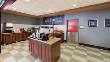 A clean, well-lit kitchen area with a coffee station, microwave, and refrigerator.
