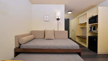A compact room with a bed, a bedside table, a lamp, and a wardrobe.
