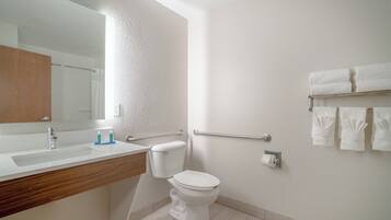 Een moderne badkamer met een witte wastafel, toilet en spiegel.