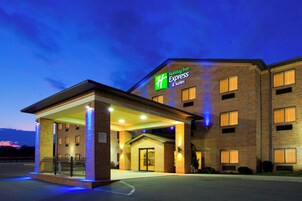 Edificio de Holiday Inn Express & Suites con fachada de ladrillo, entrada cubierta y un letrero que indica el nombre y los servicios.