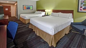 Quarto de hotel com duas camas, uma escrivaninha, uma cadeira e um abajur.