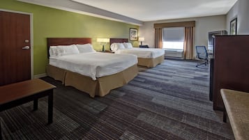 A hotel room with two beds, a desk, a chair, and a large window with curtains.