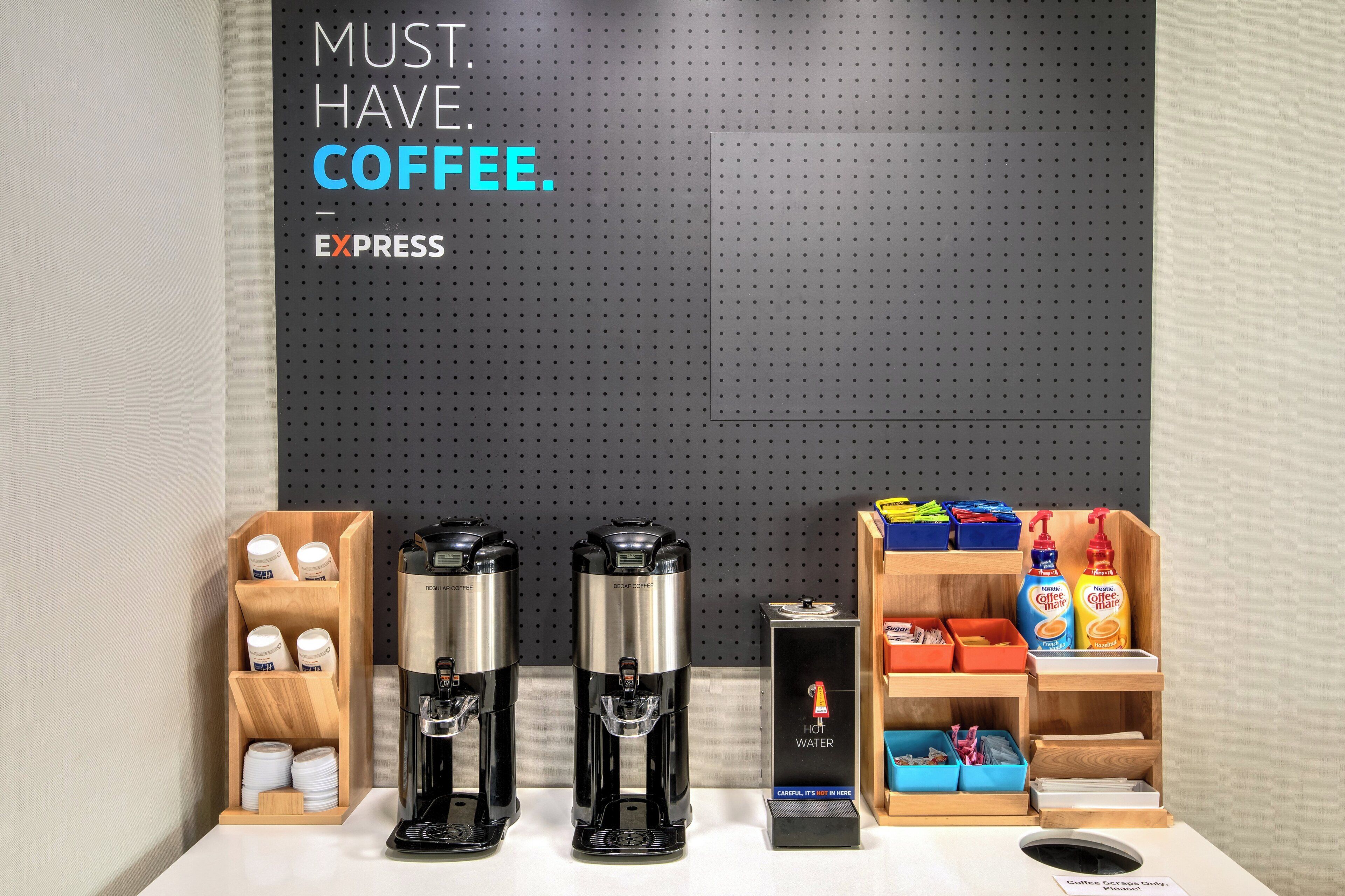 En kaffestation med två espressomaskiner, en kaffedispenser och ett urval av olika kaffeprodukter.