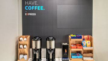 Una estación de café con dos máquinas de espresso, un dispensador de café y diversos productos de café.