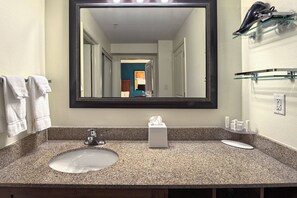 A bathroom with a granite countertop, a sink, a mirror, and a towel rack. - Residence Inn by Marriott Fayetteville Cross Creek (Fayetteville)