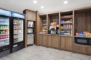 Una kitchenette equipada con refrigerador, microondas y cafetera.