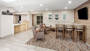 A hotel reception area with a reception desk, seating, and artwork on the walls.