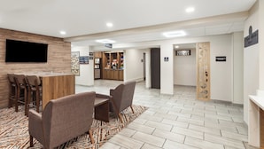 A reception area with a bar, seating, and a television.