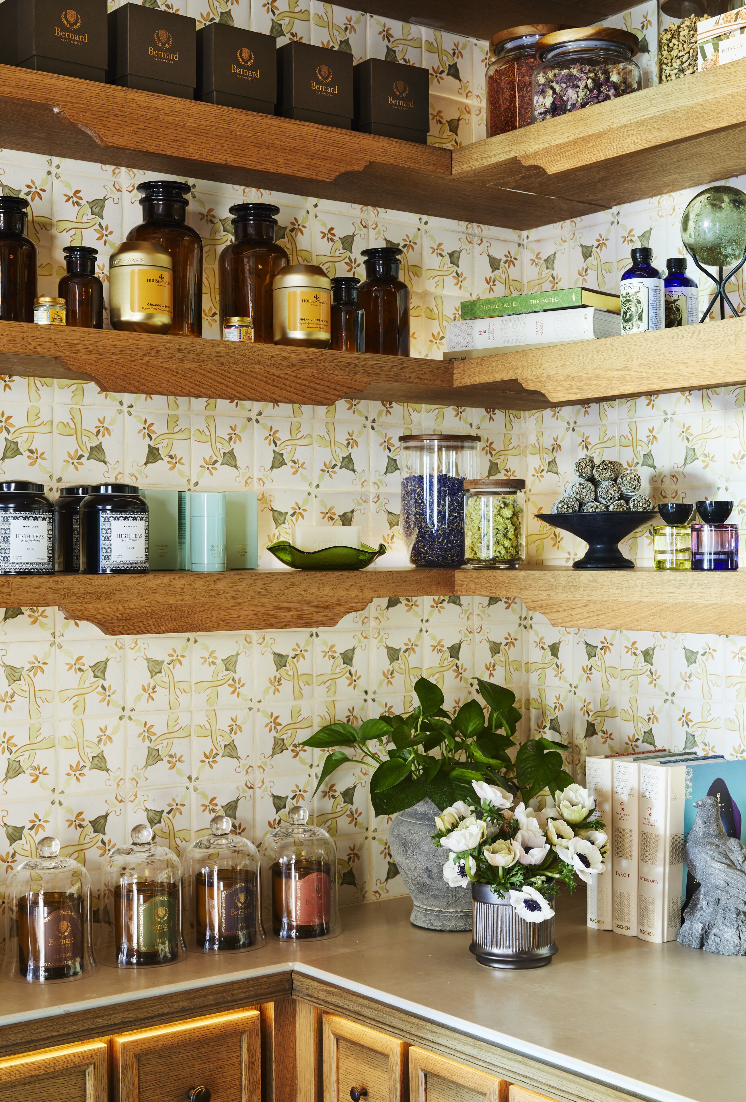 A kitchen with wooden shelves holding various kitchenware and decorative items.