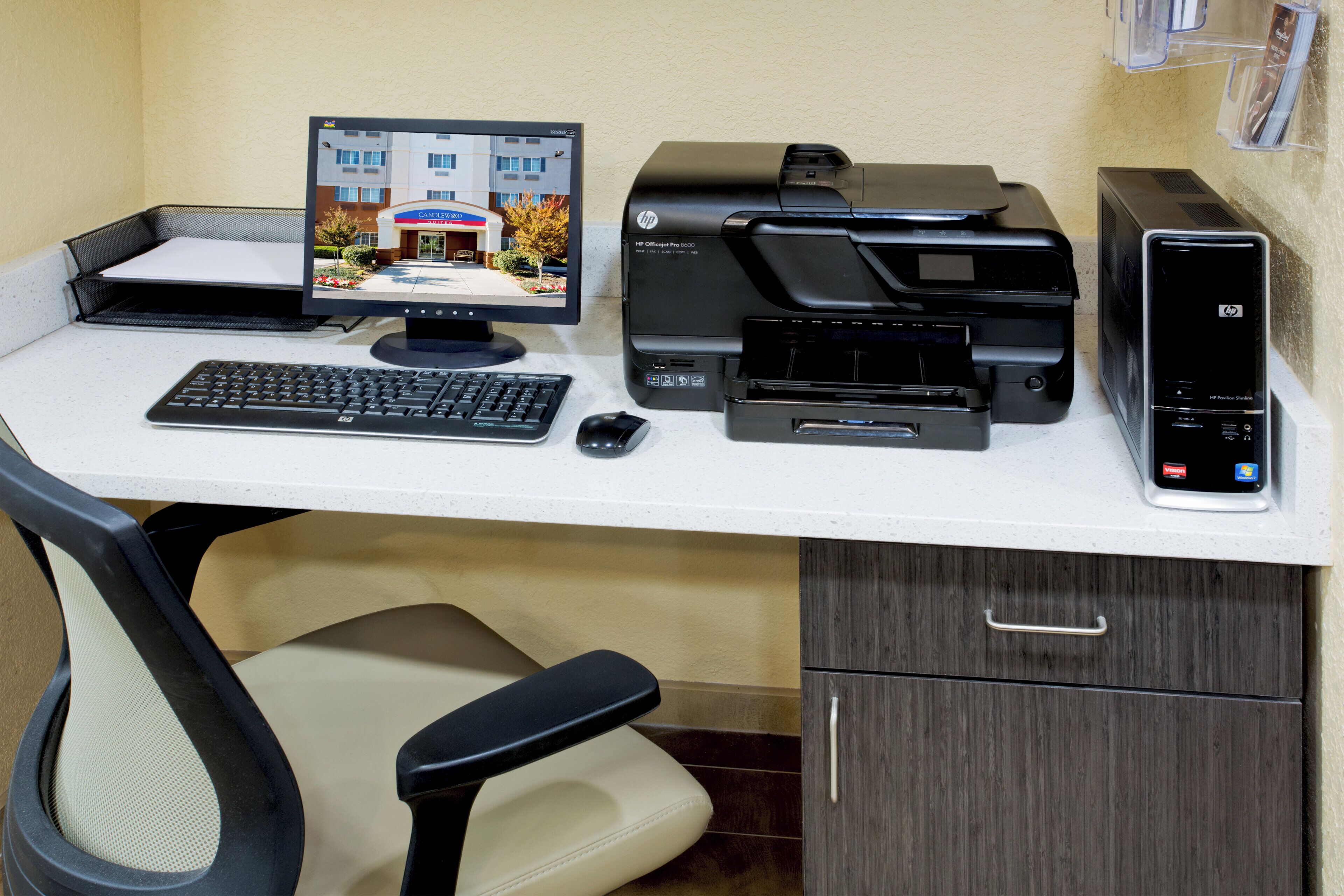 A home office setup with a desktop computer, printer, and keyboard.