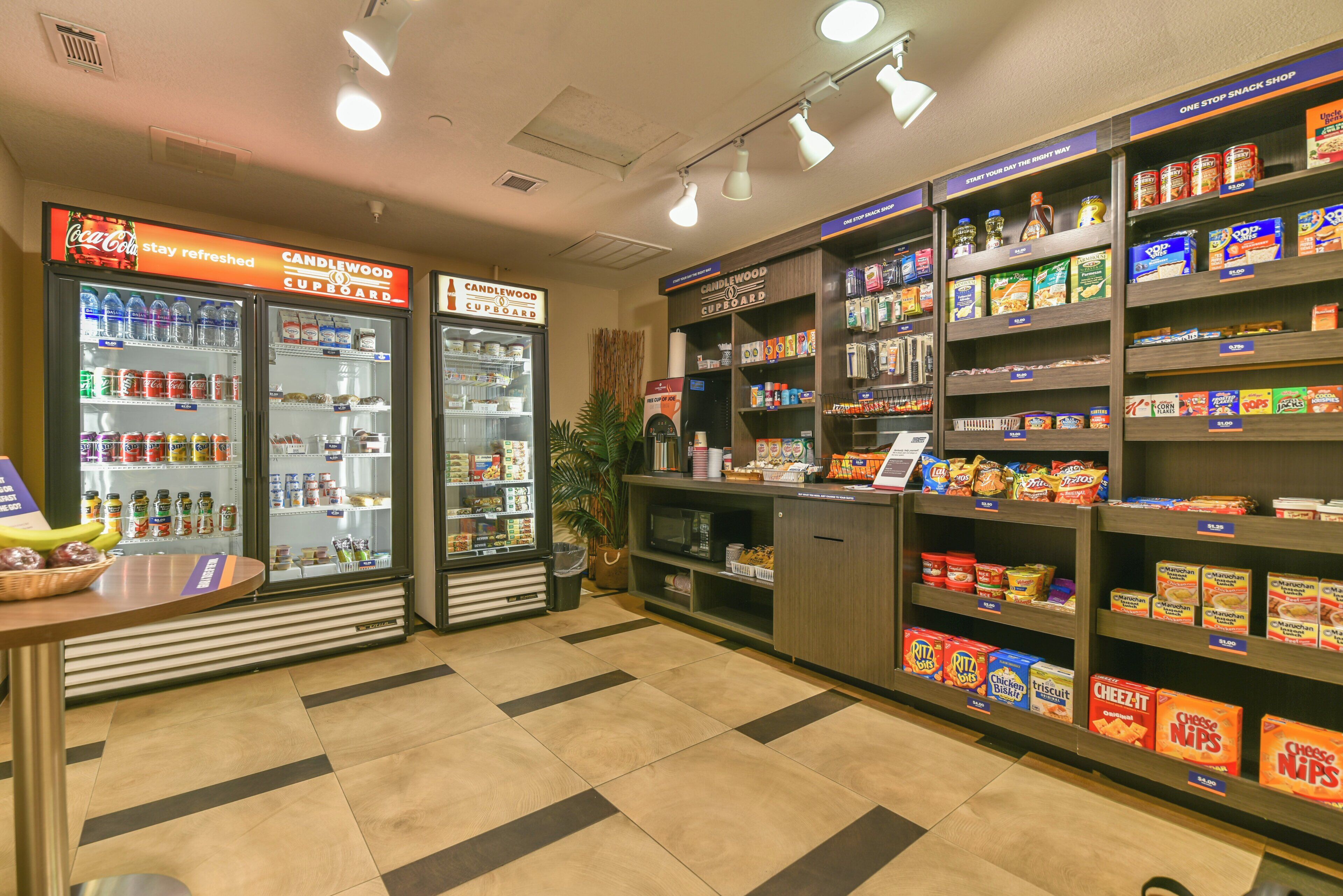 Un magasin proposant des boissons fraîches en distributeur, une variété de collations et une caisse enregistreuse.