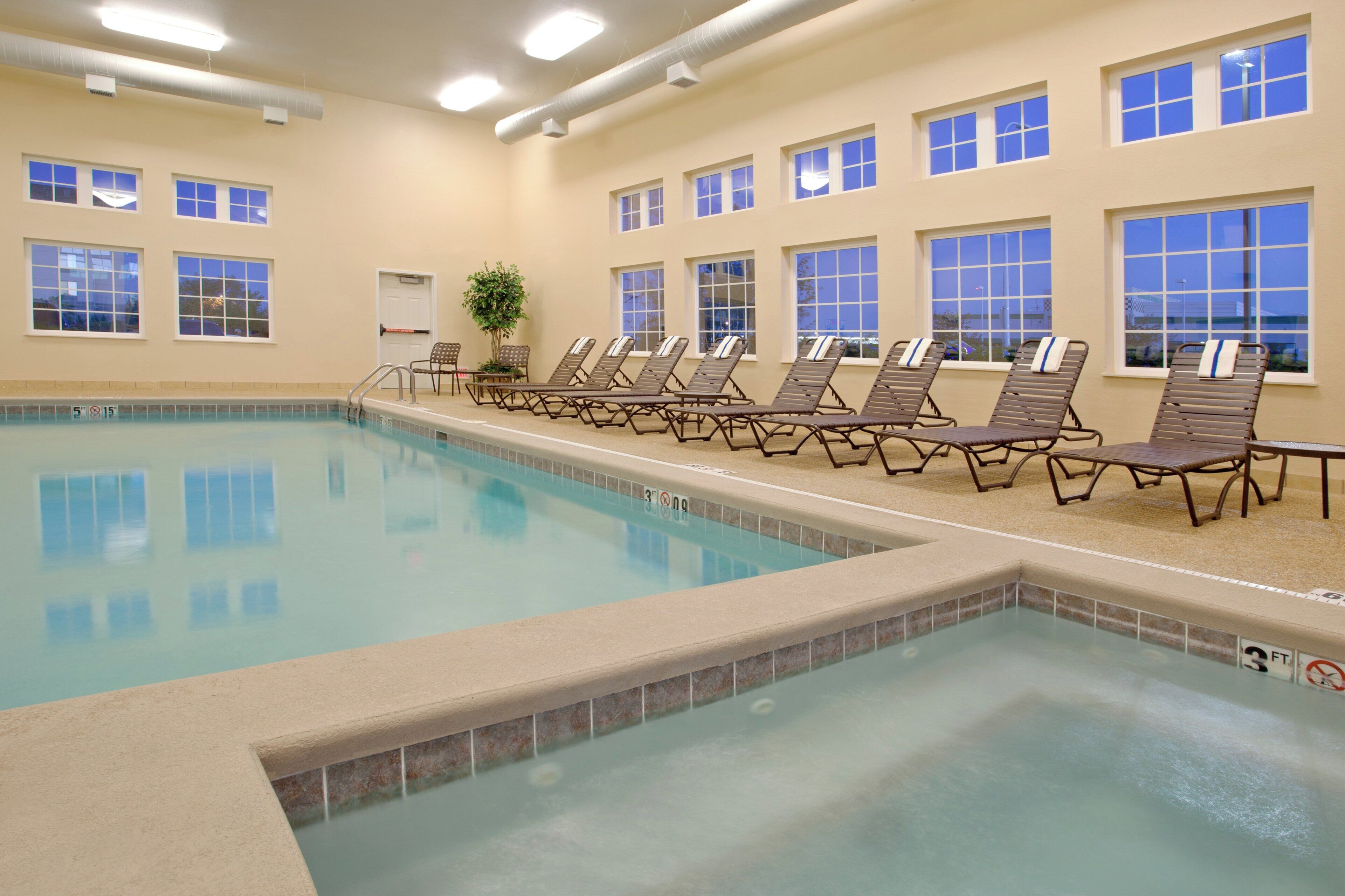 A swimming pool with lounge chairs and a door.