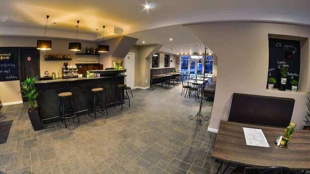 A modern restaurant with a bar area, seating, and a chalkboard menu. - Sesame (Riga)