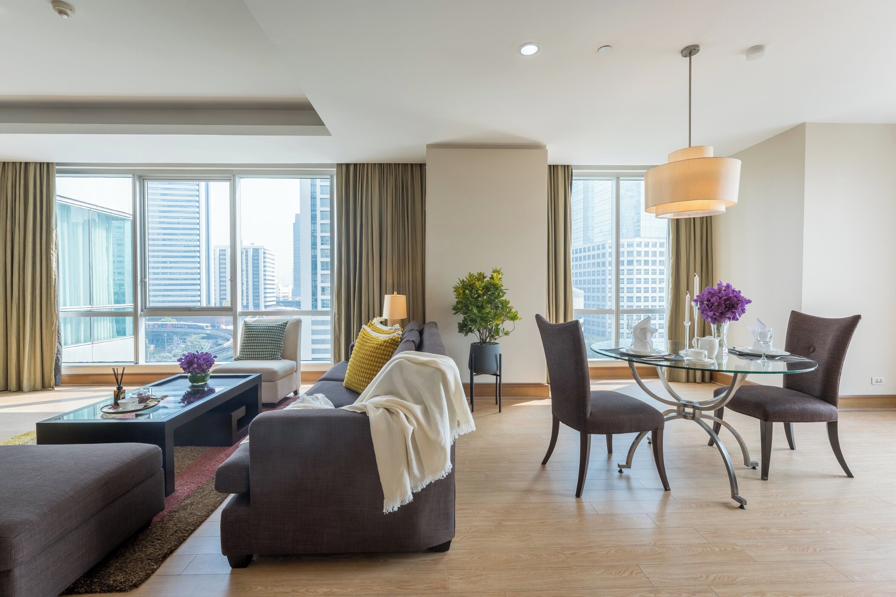A modern living room with a sofa, coffee table, and dining table.