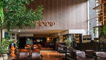 A modern interior with a bar area, seating, and a visible sign with the name 'ELLY'.
