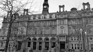 A historic building with a prominent clock tower, arched windows, and classical architecture.