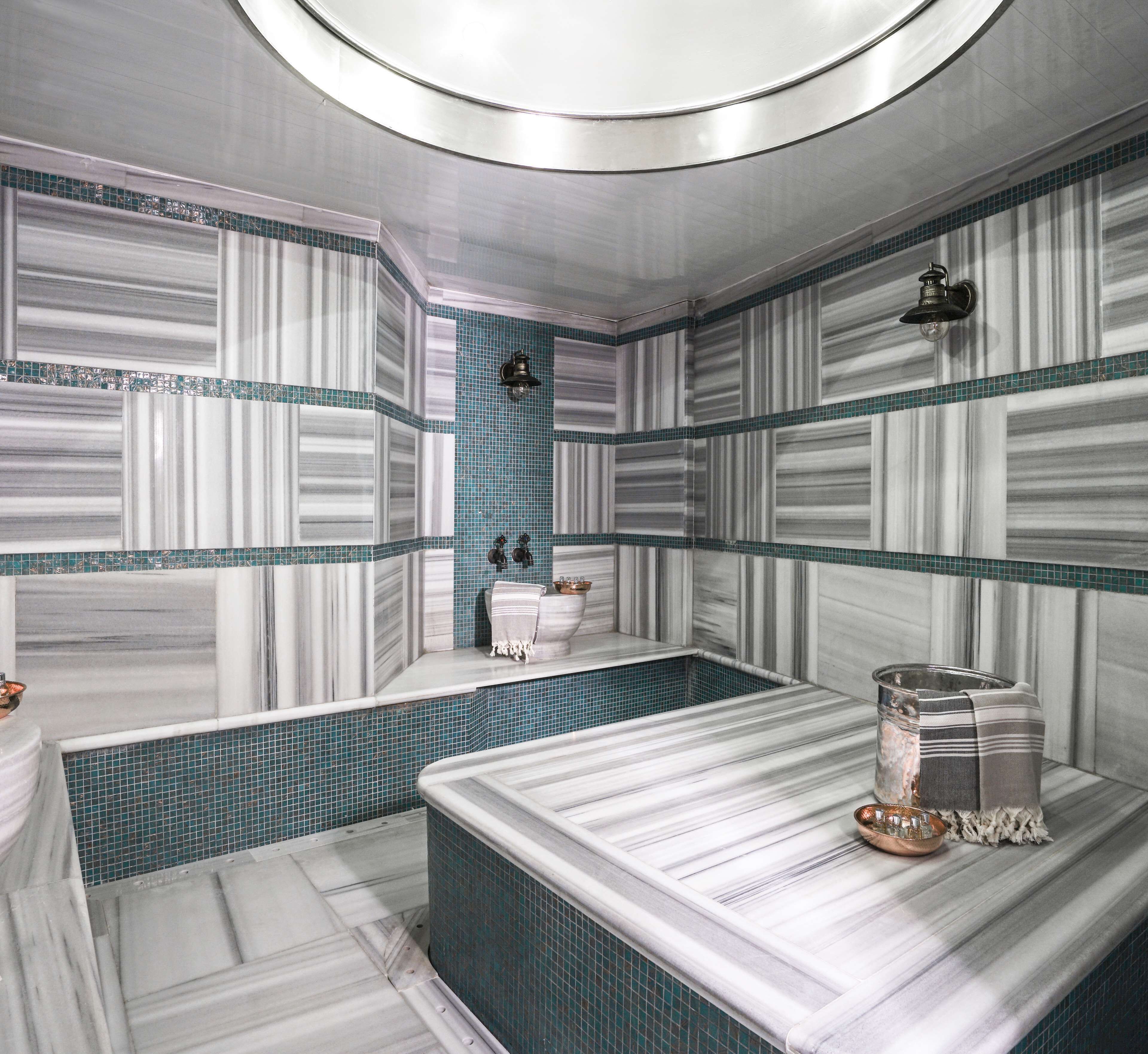 Une salle de bain moderne avec un meuble-lavabo en marbre, une baignoire et un espace douche.