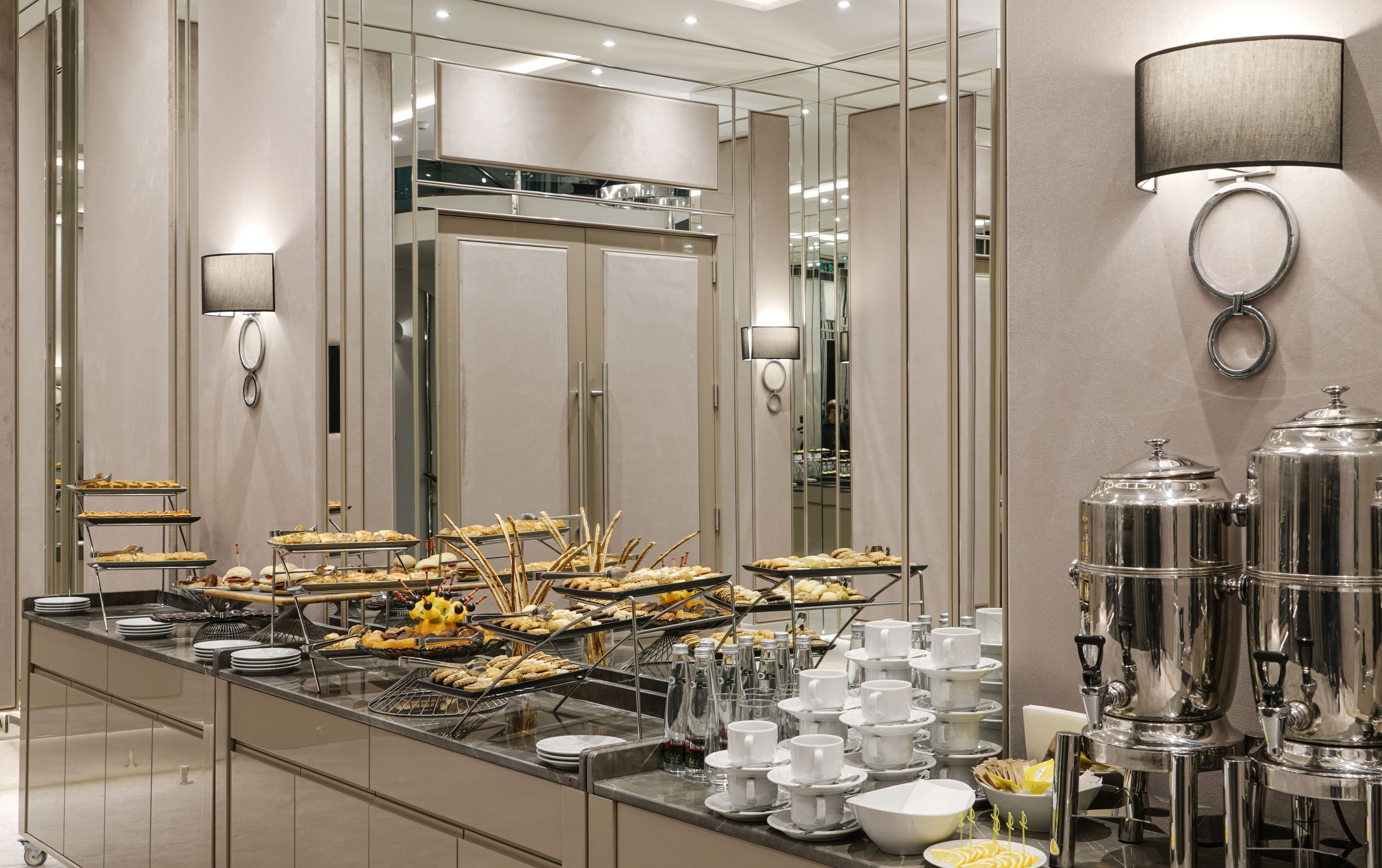 Disposição de buffet com diversos alimentos e dispensadores de bebidas.