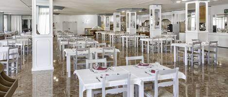 A spacious restaurant with white tables and chairs, marble flooring, and a modern interior design.