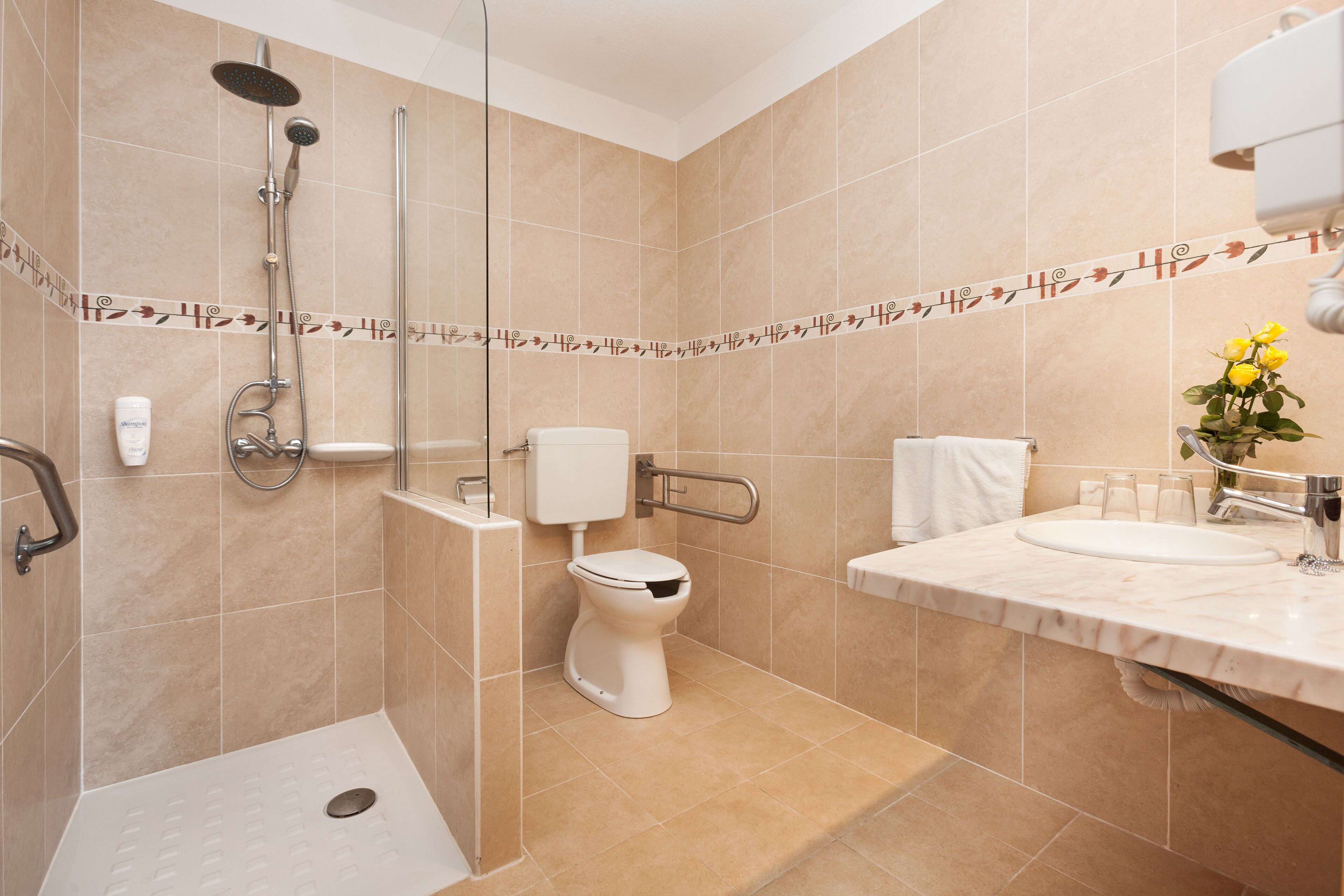 A modern bathroom with a shower, toilet, and sink.
