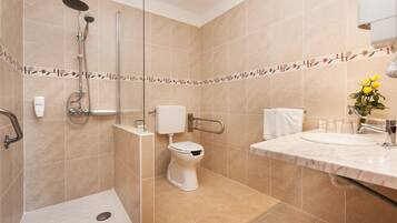 A modern bathroom with a shower, toilet, and sink.