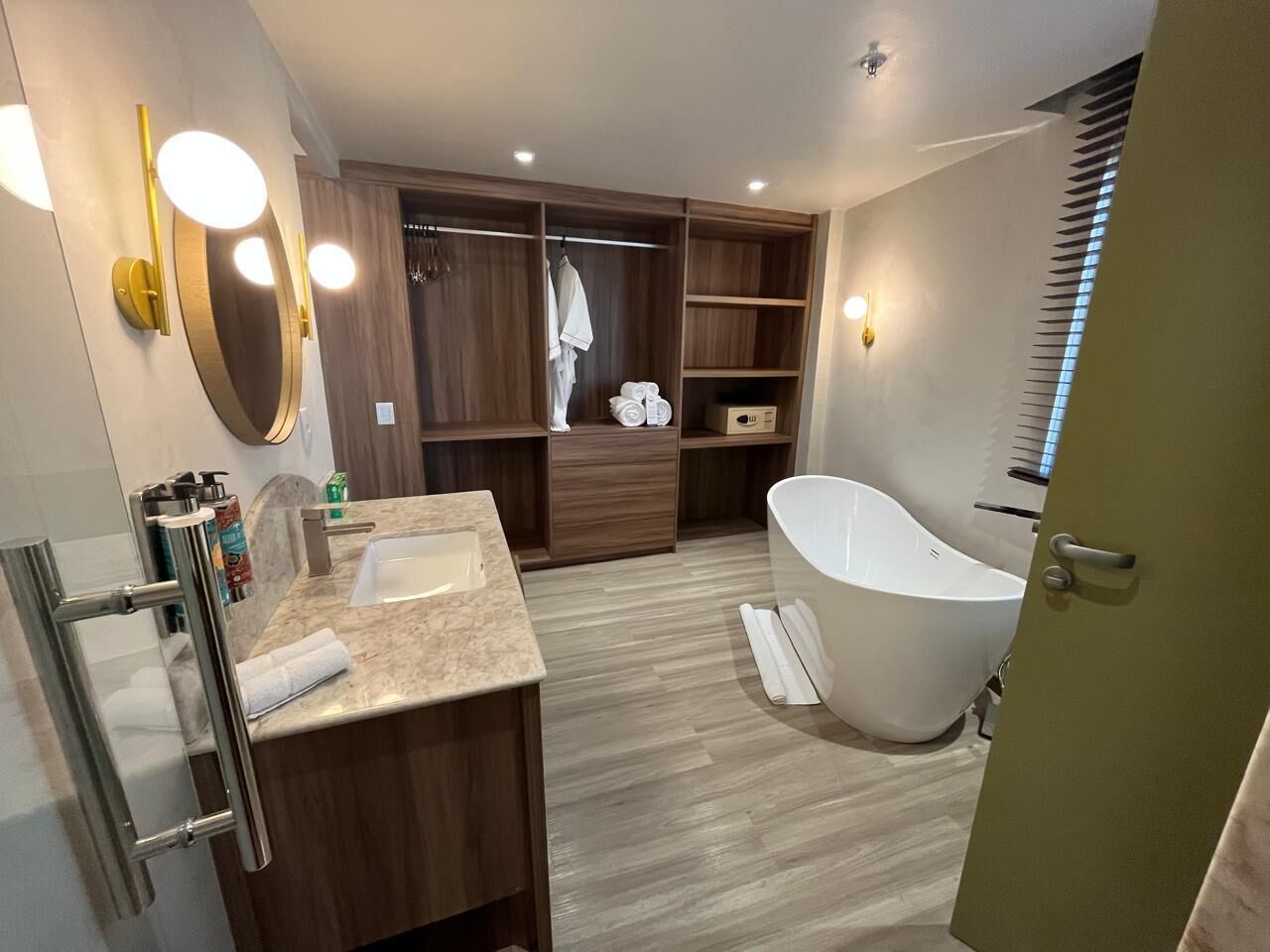Ein modernes Badezimmer mit freistehender Badewanne, einem Waschtisch und einem begehbaren Kleiderschrank.