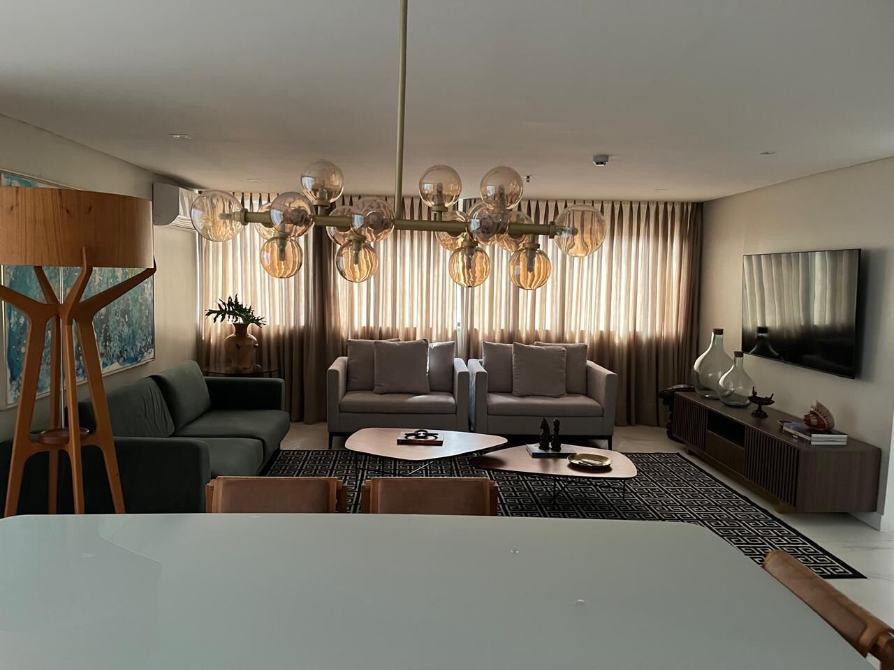 Uma sala de estar moderna com sofá, mesa de centro e um quadro na parede.