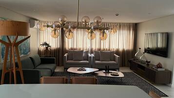 Uma sala de estar moderna com sofá, mesa de centro e um quadro na parede.