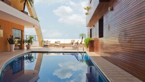 A modern indoor swimming pool with clear blue water, surrounded by lounge chairs and potted plants. - Grand Mercure Belem Do Para (Belém)