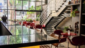 A modern interior with a bar area, seating, and a staircase leading to an upper level. - Grand Mercure Belem Do Para (Belém)